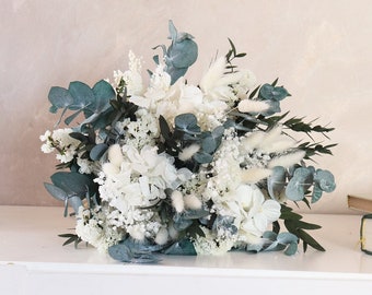 Puede incluir: Un ramo de novia blanco y azul con eucalipto, hortensias blancas y aliento de bebé blanco.
