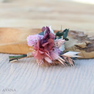 Op de afbeelding: Een klein boeket gedroogde bloemen in tinten roze, paars en wit. Het boeket bevat gedroogde hortensia's, pampasgras en andere gedroogde bloemen.