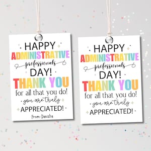 May include: Two white gift tags with the text "HAPPY ADMINISTRATIVE PROFESSIONALS DAY! THANK YOU for all that you do! you are truly APPRECIATED!" in colorful fonts. Each tag is strung with a white cord.