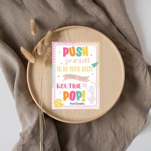 May include: A motivational quote card with a pink, yellow, green, and blue color scheme. The card features a cheerleader silhouette and the text "PUSH yourself TO DO YOUR BEST! MAKE THAT ROUTINE POP! from Danisha".
