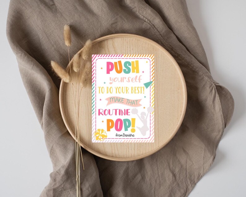 May include: A motivational quote card with a pink, yellow, green, and blue color scheme. The card features a cheerleader silhouette and the text "PUSH yourself TO DO YOUR BEST! MAKE THAT ROUTINE POP! from Danisha".