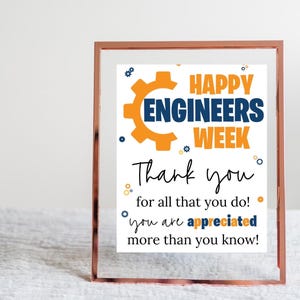 May include: A sign with a gold gear graphic and the text "Happy Engineers Week" in blue and orange. The sign also says "Thank you for all that you do! You are appreciated more than you know!"