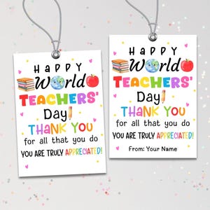Könnte beinhalten: Zwei rechteckige weiße Geschenkanhänger mit silbernen Ösen und grauen Schnüren. Der Text lautet Happy World Teachers' Day THANK YOU for all that you do YOU ARE TRULY APPRECIATED! Grafiken zeigen einen Bücherstapel, einen Globus, einen Apfel und einen Stift.