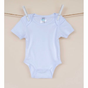 May include: White baby onesie with short sleeves and snaps at the bottom. The onesie has a label that says "CCB Blanks 0-3M Made in China".