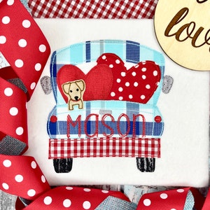 May include: A blue and white plaid pickup truck with a red heart and white polka dot heart in the bed. A small yellow dog is sitting in the bed of the truck. The truck has the name "Mason" embroidered on the back.