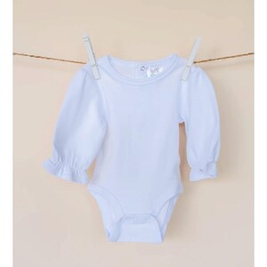 Pu&ograve; includere: Un body bianco a maniche lunghe per neonato con scollo rotondo e maniche a sbuffo. Il body ha una chiusura a pressione nella parte inferiore.