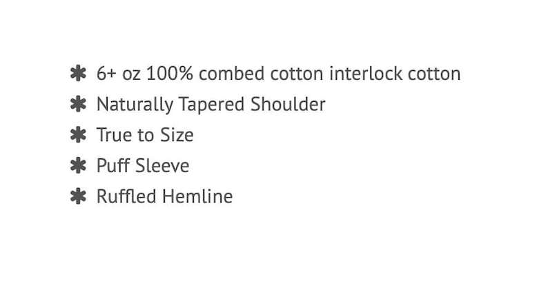 May include: Text on a white background lists product features: 6+ oz 100% combed cotton interlock cotton, Naturally Tapered Shoulder, True to Size, Puff Sleeve, and Ruffled Hemline.