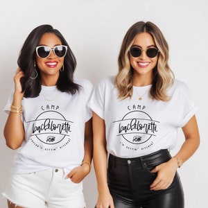 Peut inclure: Deux femmes portant des t-shirts blancs avec du texte noir qui dit "Camp Bachelorette" et une icône de camping-car. Le texte comprend également "I'm gettin' hitched!" et "Taylor's gettin' hitched!"