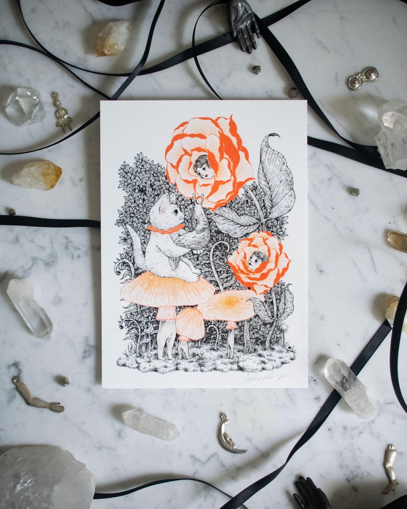 May include: Whimsical art print featuring a white cat wearing a red collar, seated on a mushroom. The illustration includes orange roses with faces, other mushrooms, and detailed black and white foliage. The artwork has a fantasy theme.