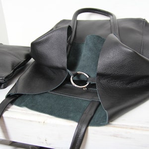 May include: Black leather tote bag with a green suede lining and a silver ring detail.