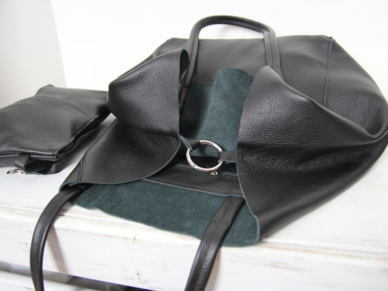 May include: Black leather tote bag with a green suede lining and a silver ring detail.
