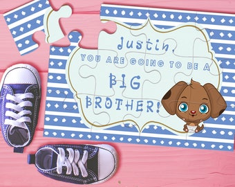 Puede incluir: Piezas de rompecabezas azules y blancas con el texto "Justin, vas a ser un hermano mayor!" y un cachorro de dibujos animados. Las piezas del rompecabezas están sobre una superficie rosa con un par de zapatillas azules.