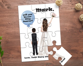 Op de afbeelding: Een wit puzzelstuk met een blauwe ballon waarop staat "will you be our Ring Bearer?" en een illustratie van een bruid en bruidegom. Het puzzelstuk heeft ook de tekst "Mark, Love. Aunt Mary and 1 Brad".
