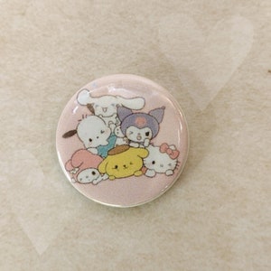 May include: A pink and white round button with a group of cartoon characters. The characters are a white dog, a purple cat, a yellow dog, a pink rabbit, and a white dog. The characters are all smiling and looking at the viewer.