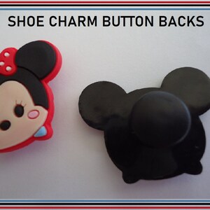 Puede incluir: Dos abalorios para zapatos, uno es un personaje de Minnie Mouse rojo y negro, el otro es un bot&oacute;n negro.