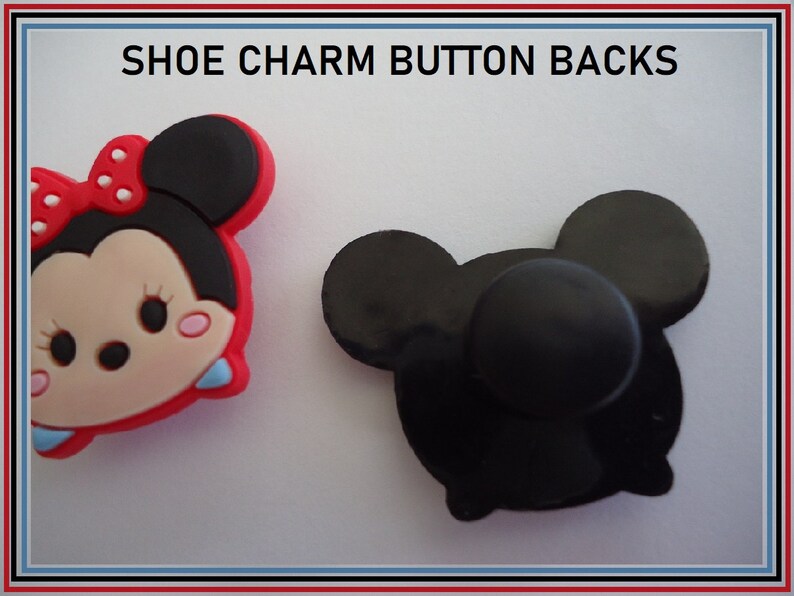 Puede incluir: Dos abalorios para zapatos, uno es un personaje de Minnie Mouse rojo y negro, el otro es un bot&oacute;n negro.