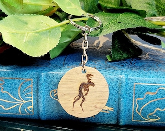 May include: A wooden keyring with a kangaroo design, hanging from a silver chain. The keyring is resting on top of a stack of books, including a copy of "The Tragedies" by Shakespeare.