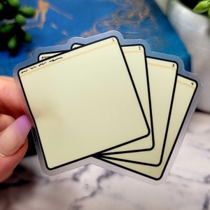 May include: Four clear, blank, rectangular stickers with rounded corners. The stickers are stacked on top of each other and have a light yellow background. The stickers are numbered 1 through 4 in the top right corner.