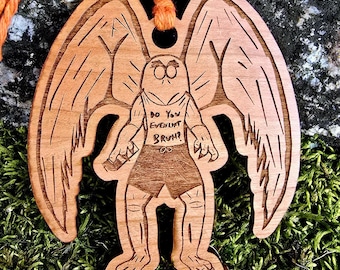 May include: Wooden ornament of a winged creature with a human-like body. The creature is wearing a shirt that says "Do you even lift bruh!" The ornament is brown and has a string for hanging.