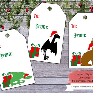 Puede incluir: Tres etiquetas de regalo imprimibles con un drag&oacute;n negro, un conejo marr&oacute;n y un drag&oacute;n verde, todos con gorros de Pap&aacute; Noel. Las etiquetas tienen las palabras "Para:" y "De:" impresas en ellas. El texto "Descarga digital instant&aacute;nea Sin producto f&iacute;sico 1 p&aacute;gina de etiquetas de regalo imprimibles" tambi&eacute;n est&aacute; incluido.