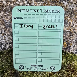 May include: A light green Initiative Tracker with rounded corners, featuring the text "Initiative Tracker" and "Round". It includes boxes for tracking and the words "Dry" and "Erase!". The bottom has the text "Jhotun's Forge".