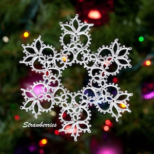 Peut inclure: Une décoration de flocon de neige en crochet blanc avec des détails complexes, suspendue sur un fond flou d'un sapin de Noël avec des lumières colorées.