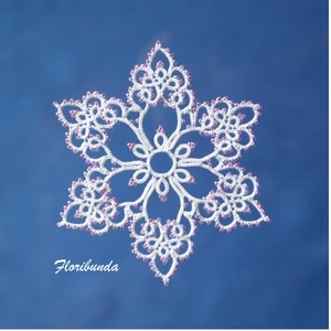 May include: A white snowflake ornament with pink beads, against a blue background. The snowflake has a delicate, intricate design and is a beautiful example of handmade lace.