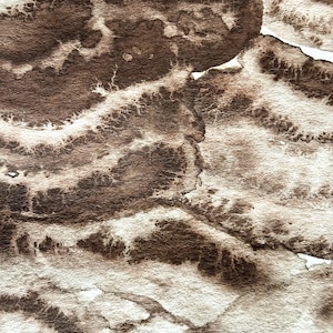 May include: Abstract watercolour painting with a textured, layered effect. The artwork features a blend of brown and off-white hues, creating a marbled or organic pattern. The colours blend and bleed into each other, with areas of lighter tones contrasting with darker, more saturated patches.