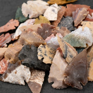 May include: A collection of arrowheads made from various types of stone, including flint, jasper, and agate. The arrowheads are in a variety of colors, including brown, gray, white, and red. They are all in good condition and have been carefully preserved.