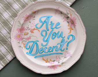 Plato decorativo vintage pintado a mano: letras en verde azulado, decoración floral de estilo campestre.