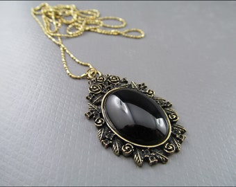 Collier noble avec la pierre de verre noire, encadrée dans des roses - mystérieuse et magique