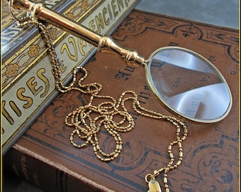 Beautiful classic golden magnifying glass with long handle on the chain, 2.5x magnification