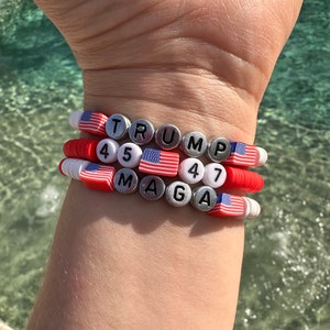 Pu&ograve; includere: Un braccialetto con perline rosse, bianche e blu che compongono la scritta "TRUMP 45 MAGA 47".