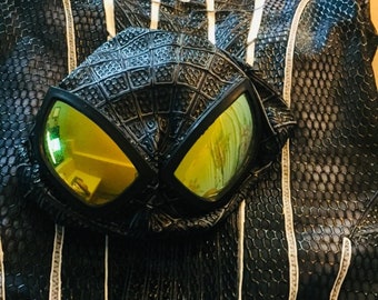 May include: Black and white spider-man costume with a black mask with yellow lenses. The costume has a web pattern and white accents.