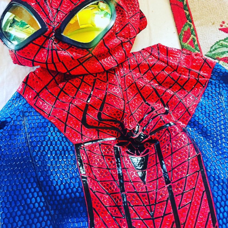 May include: A red and blue Spiderman costume with a black spider web design and a mask with yellow goggles.