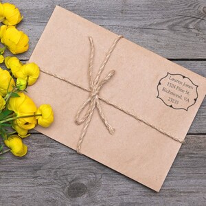 Envelope with a personalized address stamp beside yellow flowers on a wooden table. Ideal self-inking address stamp for personalized real estate gifts, adding a unique touch to correspondence.