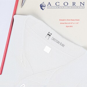 Self-inking kids stamp on a white shirt, showcasing a custom stamp for clothing. Ideal for labeling kids' clothing, this personalized stamp ensures easy identification and organization. Perfect for school uniforms and everyday wear.