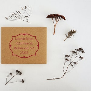 Personalized address stamp on a kraft paper envelope, ideal as an address stamp for realtors. This elegant design makes a perfect gift for realtors, featuring a sample address with decorative dried flowers.