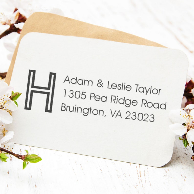 Custom address stamp featuring a name stamp design with Adam & Leslie Taylor and their address. Perfect for personalizing mail, this address stamp adds a unique touch to envelopes. Ideal for those seeking a stylish custom address stamp solution.