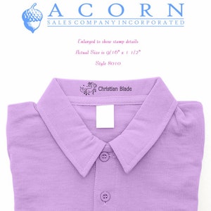 Purple shirt with a personalized self-inking name stamp for clothing, featuring an ink pad for kids stamp. The stamp displays Christian Blade in black ink, ideal for labeling garments.