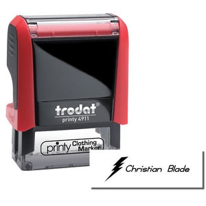 Image of a Trodat printy clothing marker, ideal for creating a school uniform stamp or name stamp for daycare. Includes a refill ink pad for stamp, ensuring long-lasting use and clear labeling of children's clothing and items.