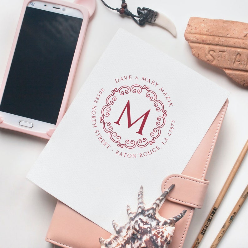 Housewarming gifts featuring personalized craft supplies and elegant home decor, including a custom monogram print, smartphone, and seashell, perfect for adding a personal touch to any space.