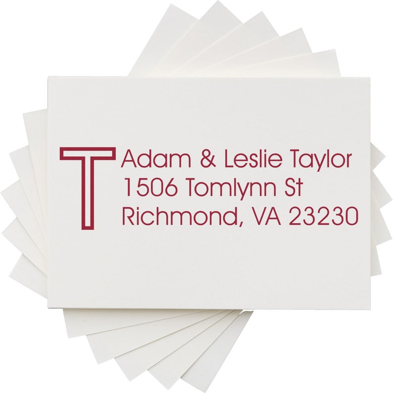 Personalized address stamp featuring a self-inking stamp design with a return address label for Adam & Leslie Taylor, 1506 Tomlynn St, Richmond, VA 23230, displayed on a stack of white cards. Ideal for efficient mailing.