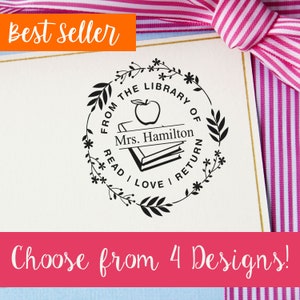 May include: Black and white stamp with a floral wreath design. The stamp says "From the Library of Mrs. Hamilton Read I Love I Return".