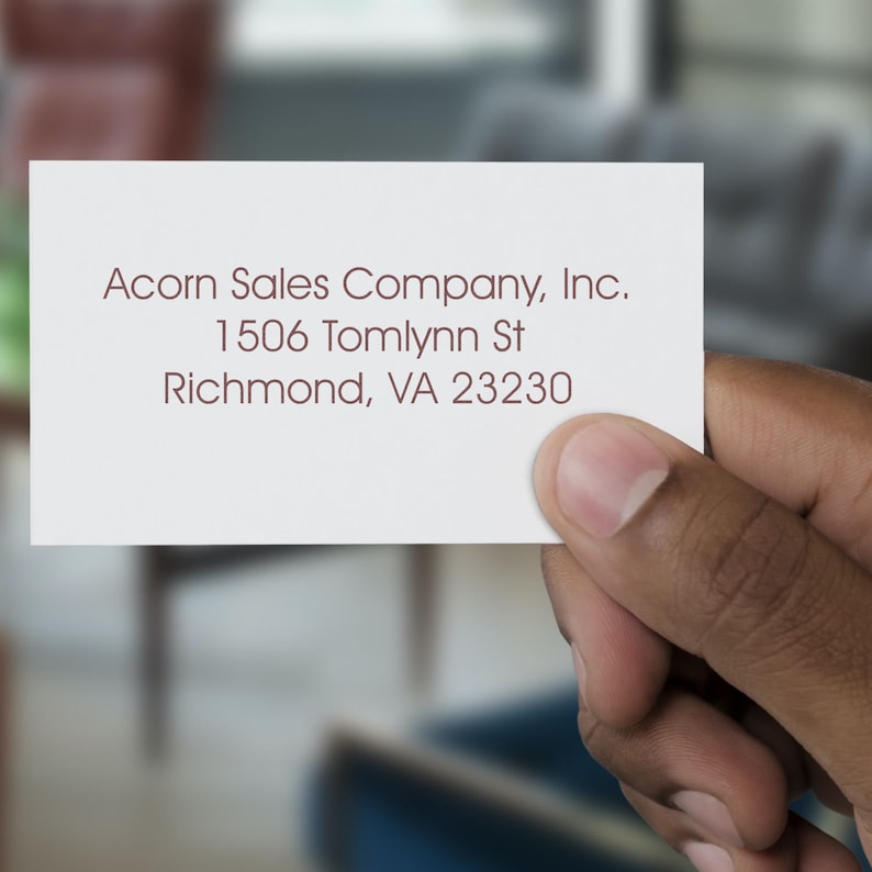 Hand holding a card with elegant calligraphy-style text, ideal for a personalized return address stamp. Perfect for creating a custom address stamp for home use, adding a touch of sophistication to your correspondence.