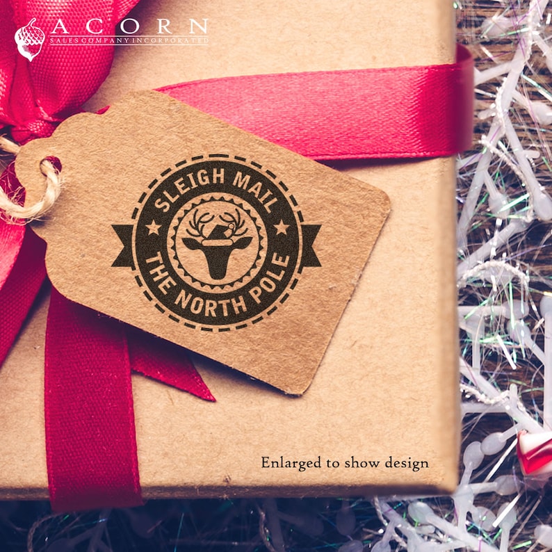 Decorative gift wrapped in brown paper with a red ribbon, featuring a creative Santa Mail Stamp and Gift Tag Stamp labeled Sleigh Mail The North Pole. Perfect for adding a festive touch to holiday presents.