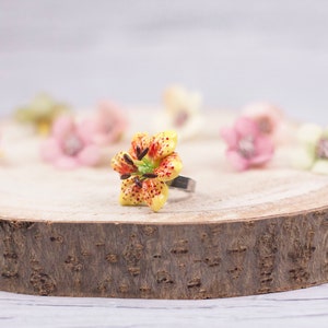 Verstellbarer Ring mit gelber Lilie aus kaltem Porzellan, von Hand modelliert und bemalt