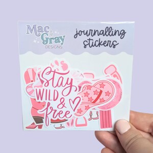 May include: A set of pink and white stickers with a western theme. The stickers feature a cowboy boot, a horseshoe, a hat, and a phrase that says "Stay Wild & Free".