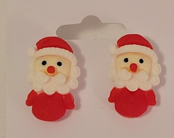 May include: A pair of red and white Santa Claus stud earrings. The earrings are made of plastic and have a 3D design.