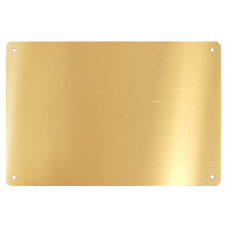 Puede incluir: Una placa de metal dorada, en blanco, con esquinas redondeadas y dos peque&ntilde;os agujeros en la parte superior e inferior.